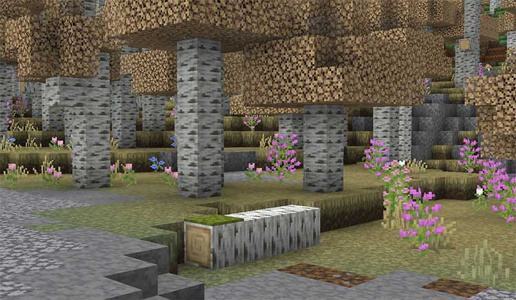 Imagen donde podemos ver el aspecto de un camino de piedra, rodeado por árboles y flores, usando el paquete de texturas Coquet.